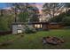 Large backyard featuring a stone fire pit, covered porch, and lush landscaping at 3356 Thornewood Dr, Atlanta, GA 30340