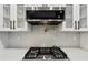 Stainless steel cooktop with modern white tile backsplash at 3356 Thornewood Dr, Atlanta, GA 30340