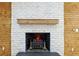 Close up of fireplace featuring a white brick surround, wooden mantel, and decorative accents at 3356 Thornewood Dr, Atlanta, GA 30340