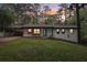 Inviting exterior showcasing a modern blue front door, manicured lawn, and long driveway to covered carport at 3356 Thornewood Dr, Atlanta, GA 30340