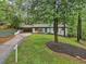 Charming home featuring a well-manicured lawn, long driveway, modern blue door, and mature trees providing ample shade at 3356 Thornewood Dr, Atlanta, GA 30340