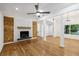 Spacious living room featuring hardwood floors, a brick fireplace, modern lighting, and large windows at 3356 Thornewood Dr, Atlanta, GA 30340