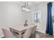 Bright dining area featuring a modern pendant light fixture and access to the backyard at 6179 Centennial Run, Atlanta, GA 30349