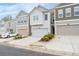 Three neutral colored townhomes each featuring a single car garage and driveway at 6179 Centennial Run, Atlanta, GA 30349