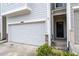 Attached garage with black front door and small landscaped yard at 6179 Centennial Run, Atlanta, GA 30349
