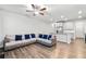 Open-concept living room with an adjacent kitchen island, gray sofa, and hardwood floors at 6179 Centennial Run, Atlanta, GA 30349