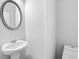 Neutral powder room with pedestal sink and rounded mirror at 6179 Centennial Run, Atlanta, GA 30349