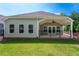 A spacious backyard featuring a covered patio, ceiling fan, and lush green lawn at 7 Hickory Branch, Hiram, GA 30141