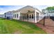 A spacious backyard with a covered patio featuring a ceiling fan and a sleek black fence at 7 Hickory Branch, Hiram, GA 30141