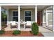 Inviting front porch with rocking chairs, columns and a welcoming red door at 7 Hickory Branch, Hiram, GA 30141