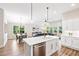 Modern kitchen flowing into the living room and dining area with island seating and ample light at 7 Hickory Branch, Hiram, GA 30141