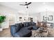 Open-concept living room with a large, comfortable sectional couch and modern ceiling fan at 7 Hickory Branch, Hiram, GA 30141