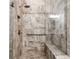 Walk-in shower featuring gray stone-look tile, rain shower head and bench at 7 Hickory Branch, Hiram, GA 30141
