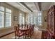 Formal dining room features a large wood table, detailed rug, and natural lighting through shuttered windows at 1691 Doncaster Ne Dr, Atlanta, GA 30309