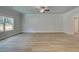 Open living room features wood-look flooring, large windows, crown molding, and a modern ceiling fan at 4574 Eastbrook Pl, Snellville, GA 30039