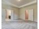 Spacious carpeted main bedroom featuring neutral walls and entryways to the bathroom and walk-in closet at 4574 Eastbrook Pl, Snellville, GA 30039