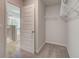 Empty, carpeted walk-in closet with wire shelving for storage and view of the ensuite bathroom at 4574 Eastbrook Pl, Snellville, GA 30039