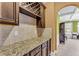 Wet bar area featuring granite countertop, wine rack, dark wood cabinets, and tile backsplash at 80 Lanier Rdg, Acworth, GA 30101