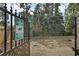 Fenced pet exercise area with gravel surface, sign, and mature trees, perfect for pet owners at 869 Briarcliff Ne Rd # B11, Atlanta, GA 30306