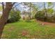 Lush backyard with mature trees, green lawn, and patio, offering a serene outdoor living and entertaining space at 51 Willow Wood Se Cir, Atlanta, GA 30317