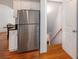 Galley kitchen featuring stainless steel appliances, white cabinets, hardwood floors, and a staircase to the basement at 51 Willow Wood Se Cir, Atlanta, GA 30317