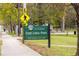 A sign indicating 'East Lake Park' with nearby pedestrian crossing, benches and trees, adding to the community's appeal at 51 Willow Wood Se Cir, Atlanta, GA 30317