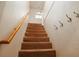 Carpeted staircase with wooden handrail and coat hooks along a white wall at 51 Willow Wood Se Cir, Atlanta, GA 30317
