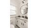 Updated bathroom features large round mirror, granite vanity, and ample natural light at 891 Spencer Nw St, Atlanta, GA 30314