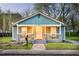 Charming cottage-style home featuring a cozy front porch and freshly landscaped front yard with flower beds at 891 Spencer Nw St, Atlanta, GA 30314