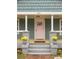 Close-up view of the home's entrance, featuring a charming pink front door, flowers, and well-kept steps at 891 Spencer Nw St, Atlanta, GA 30314