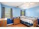 Inviting bedroom featuring wood floors, natural light, and blue walls at 1019 James Madison Ct, Mcdonough, GA 30253