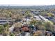 A lovely aerial shot of a red brick house nestled in a vibrant, tree-filled neighborhood with city views at 102 Defoors Mill Dr, Atlanta, GA 30318