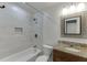 Bright bathroom with shower-tub combo, stylish mirror, granite countertop, and updated fixtures at 102 Defoors Mill Dr, Atlanta, GA 30318