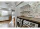Modern laundry area adjacent to the kitchen features stainless steel washer/dryer and ample workspace with stylish decor at 102 Defoors Mill Dr, Atlanta, GA 30318