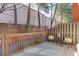 Private patio with seating area, decorative fence, and mature trees at 102 Defoors Mill Dr, Atlanta, GA 30318