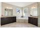 Bright bathroom with double sinks, granite counters, a soaking tub, and decorative lighting at 2172 Haventree Ct, Lawrenceville, GA 30043