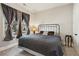 Comfortable bedroom featuring a window with curtains, lamp, and a metal bed frame at 2172 Haventree Ct, Lawrenceville, GA 30043