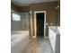 Bright bathroom featuring double vanity, tile floors, a glass-enclosed shower, and a separate soaking tub at 227 Shellbark Dr, Mcdonough, GA 30252