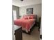 Cozy bedroom with plush carpeting, a comfortable bed with a red comforter, and natural light from a window at 227 Shellbark Dr, Mcdonough, GA 30252