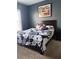 Comfortable bedroom showcasing a dark wood bed frame with a patterned comforter and decorative pillows at 227 Shellbark Dr, Mcdonough, GA 30252