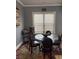 Dining room features a glass table, four chairs, and natural light from the window at 227 Shellbark Dr, Mcdonough, GA 30252