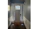 Bright foyer features a door with sidelights, dark wood flooring, and wainscotting at 227 Shellbark Dr, Mcdonough, GA 30252