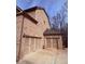 Three-car garage with traditional doors and brick exterior, offering ample parking and storage at 227 Shellbark Dr, Mcdonough, GA 30252