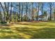 Lush backyard featuring a well-maintained lawn, mature trees, and a play area, ideal for Gathering fun at 615 Collier Nw Rd, Atlanta, GA 30318