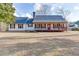 Charming single-story home featuring a cozy front porch, well-maintained lawn, and classic design elements at 1195 Braselton Hwy, Lawrenceville, GA 30043