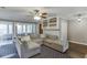 Open-concept living room featuring a large sectional couch, built-in shelving, and modern ceiling fan at 1195 Braselton Hwy, Lawrenceville, GA 30043