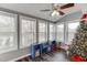 Bright sunroom features large windows, hardwood floors, custom bench, and a ceiling fan at 1195 Braselton Hwy, Lawrenceville, GA 30043