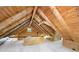 Log cabin attic space with exposed beams, finished flooring, and a window for natural light at 1615 Hilltop Ct, Woodstock, GA 30188