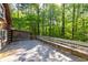Wooden deck with built-in benches surrounded by lush trees offers a serene outdoor space at 1615 Hilltop Ct, Woodstock, GA 30188