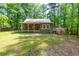 Rustic log cabin with a metal roof and a covered front porch nestled among the trees at 1615 Hilltop Ct, Woodstock, GA 30188